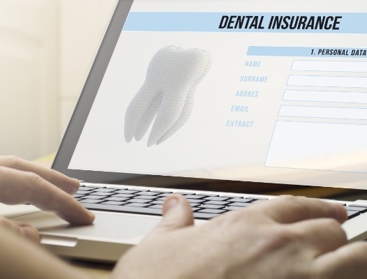 Person filling out dental insurance forms on computer screen