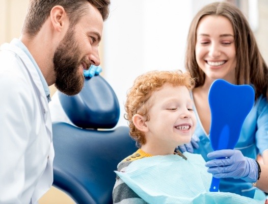 Mother and child talking to dentist in dental treatment room