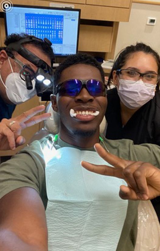 Dentist dental team member and patient smiling together