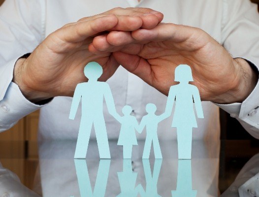 Hands covering family made of paper