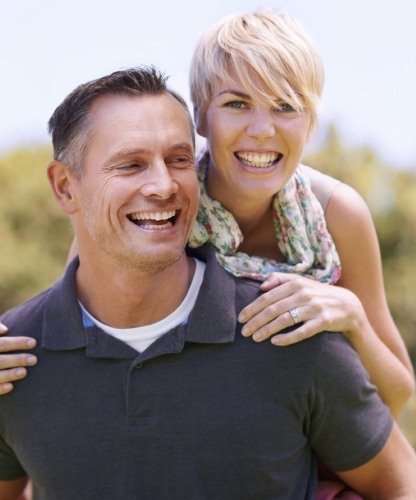 Man and woman with healthy smiles after restorative dentistry